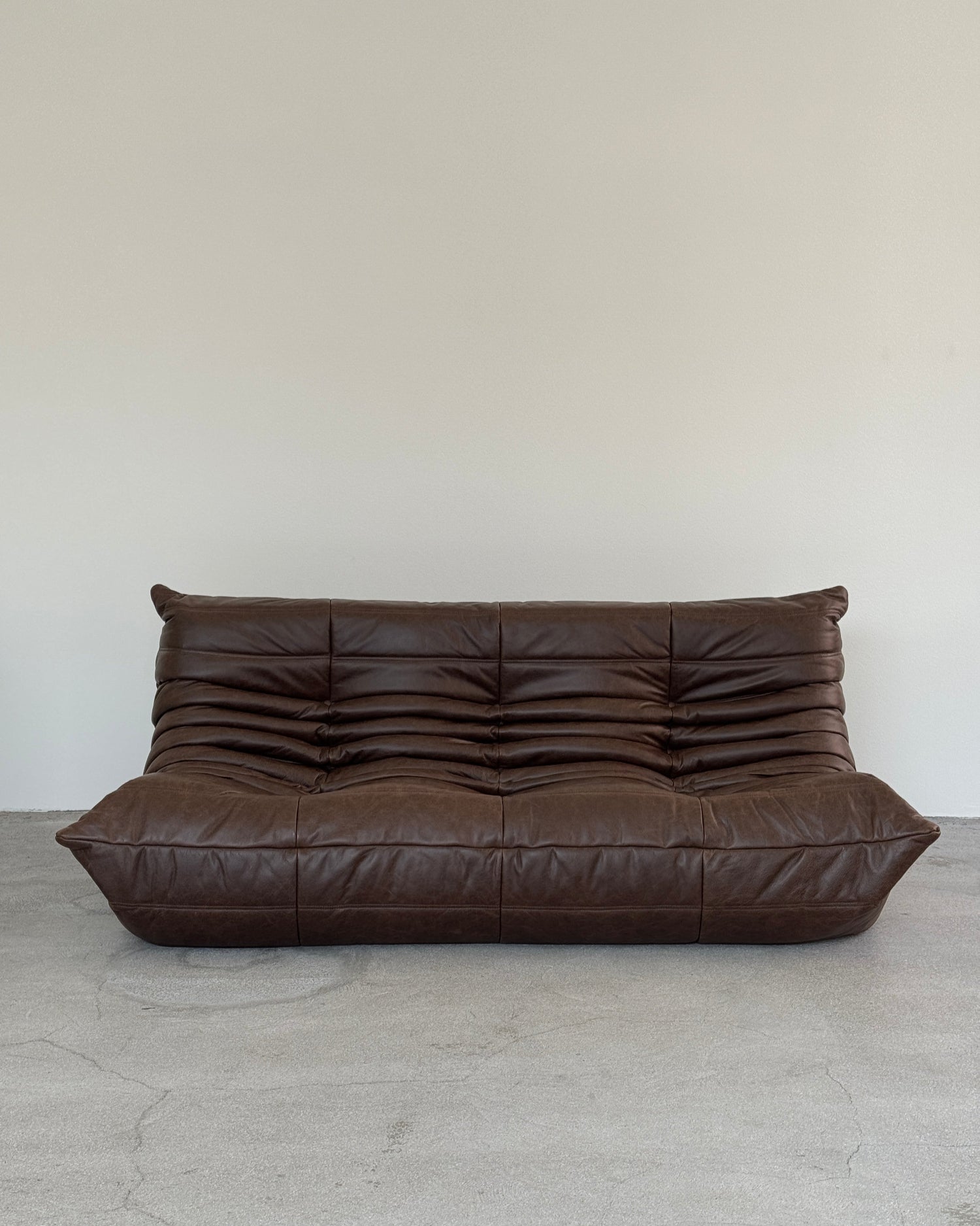 Brown leather sofa against a light gray wall