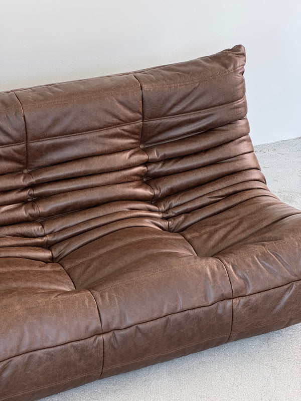 Brown leather sofa on a light gray background