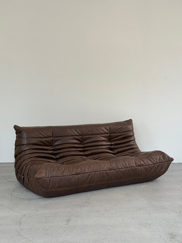 Brown leather togo sofa on a gray surface