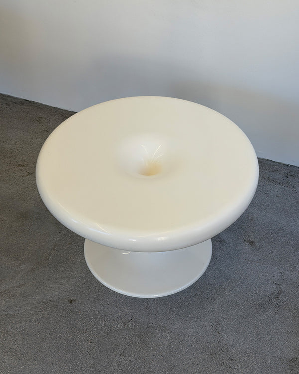 White Eero Aarnio Kanttarelli table on a gray surface with a white background