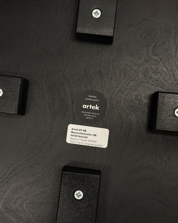 Artek branding on a textured black background