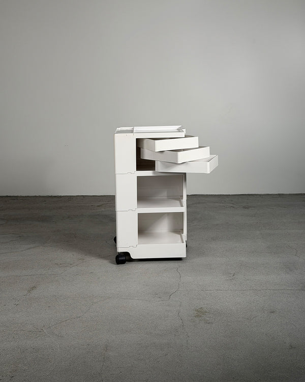 White rolling cart with drawers on a gray floor and background