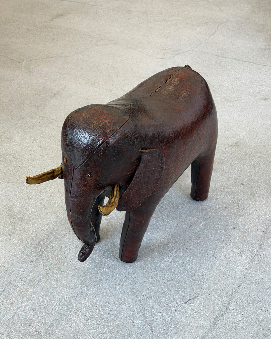 Leather Dimitri Omersa elephant figure on a textured surface with a plain background