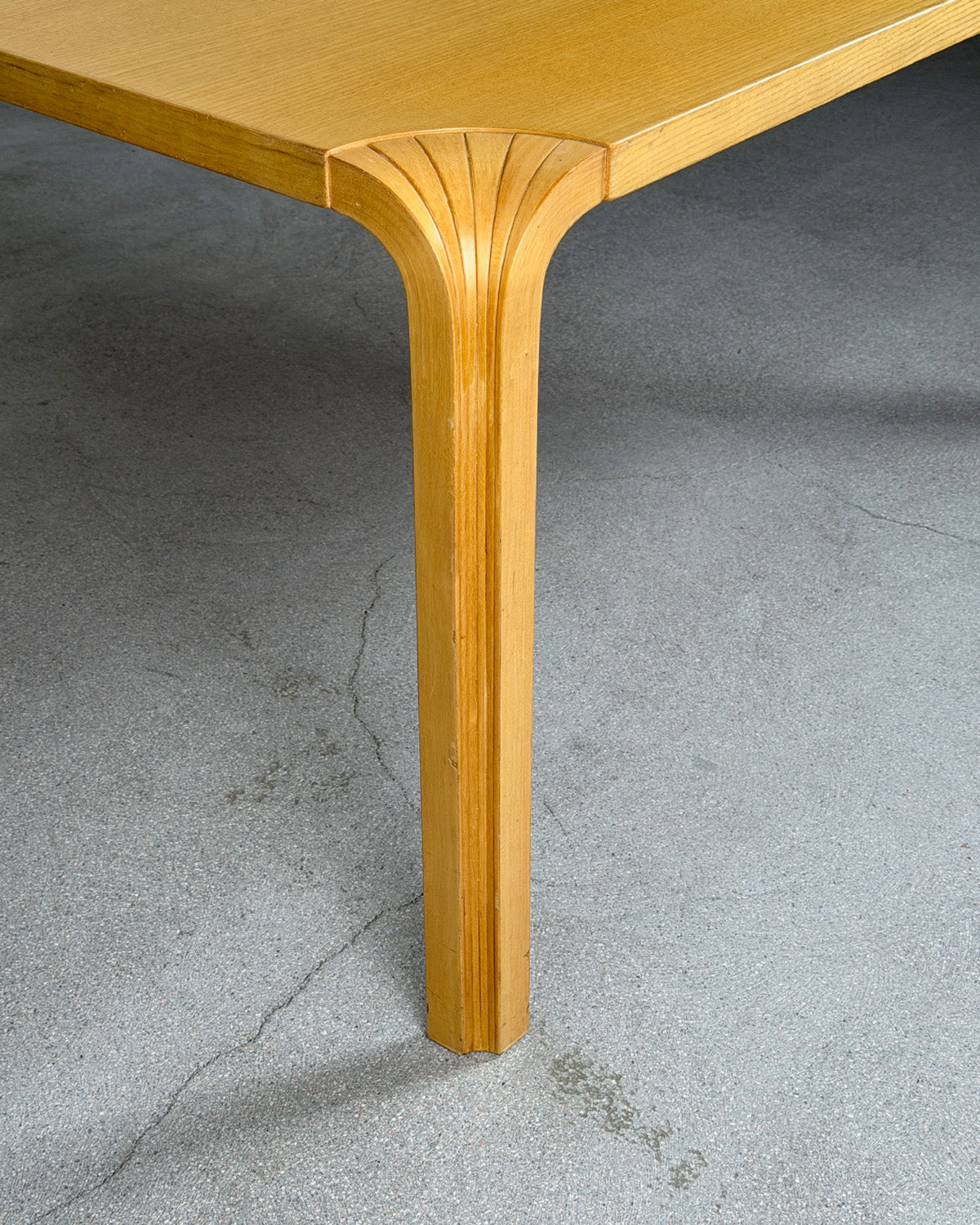 Wooden table leg on a gray concrete floor