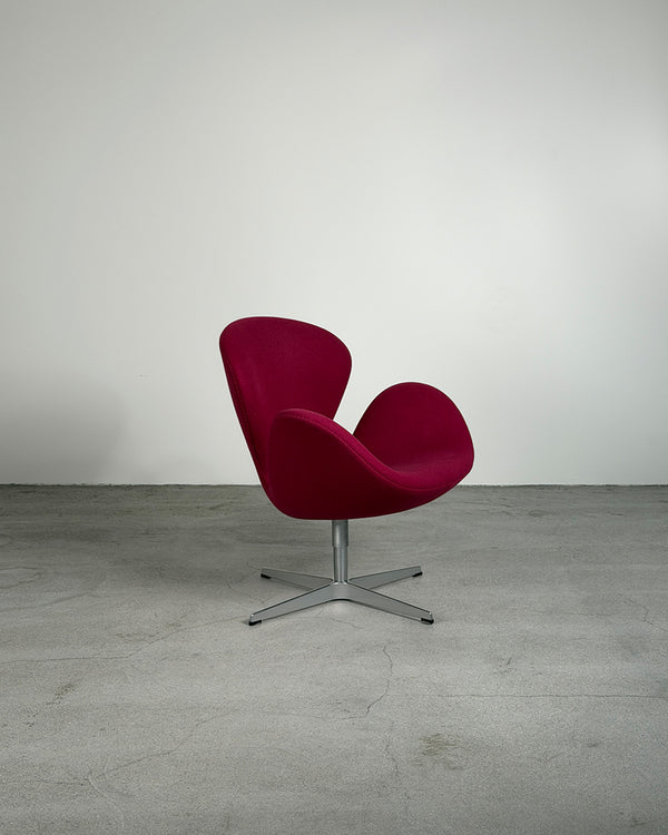 Red chair with a metal base on a gray floor and white wall