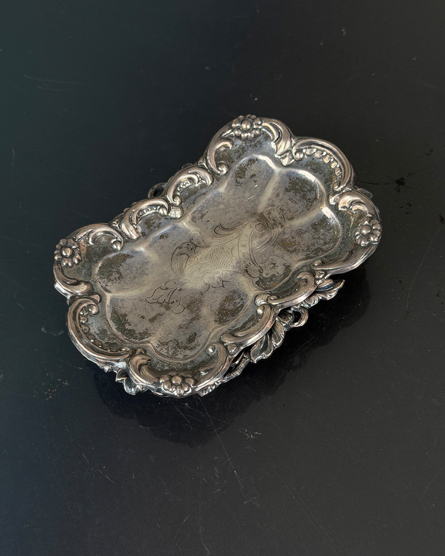 Decorative silver tray on a black background