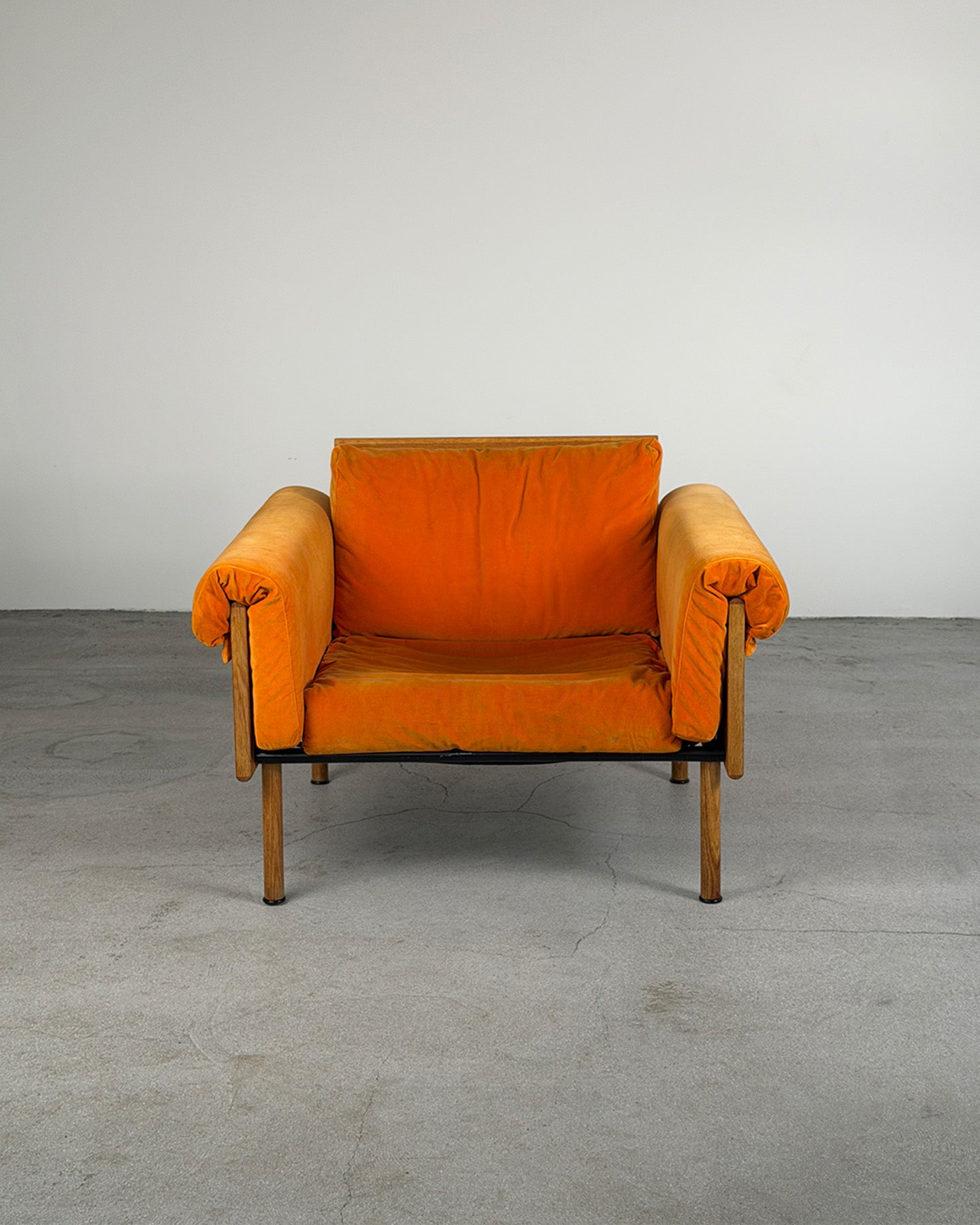 Orange armchair on a gray floor with a white wall background