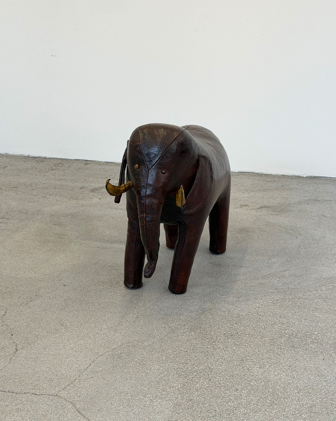 Leather Dimitri Omersa elephant figure on a textured surface with a plain background