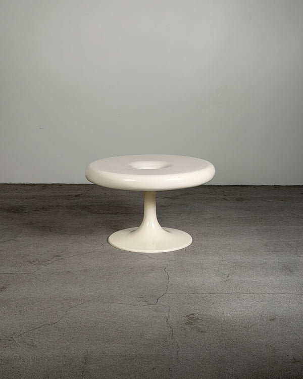 White Eero Aarnio Kanttarelli table on a gray surface with a white background
